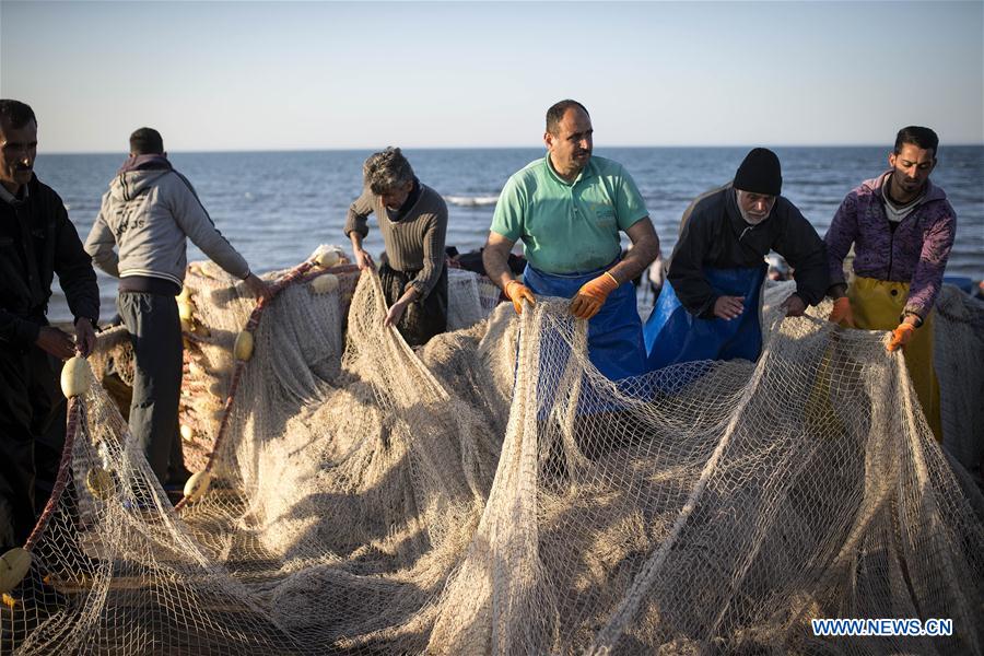 Iranian fishermen work at the Caspian sea beach near Anzali Port, northern Iran, on March 27, 2017. (Xinhua/Ahmad Halabisaz) 