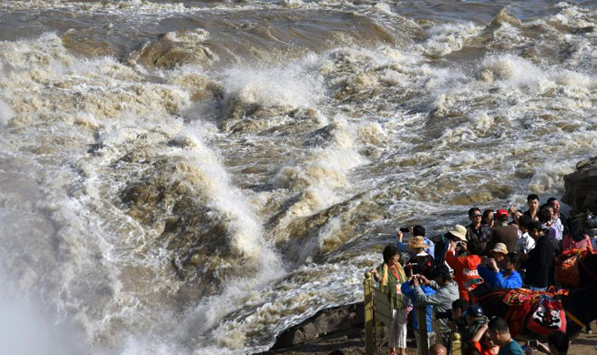 Tourists view Hukou Waterfall of Yellow River in north China's Shanxi