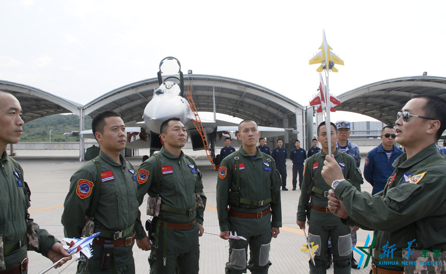 ↑艦載航空兵某部司令員戴明盟向飛行員演示空中飛行注意事項。