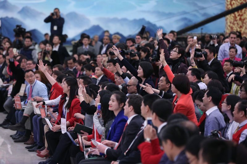 3月15日，國務院總理李克強在北京人民大會堂與中外記者見面，并回答記者提問。這是記者舉手爭取提問機會。 新華社記者 才揚 攝