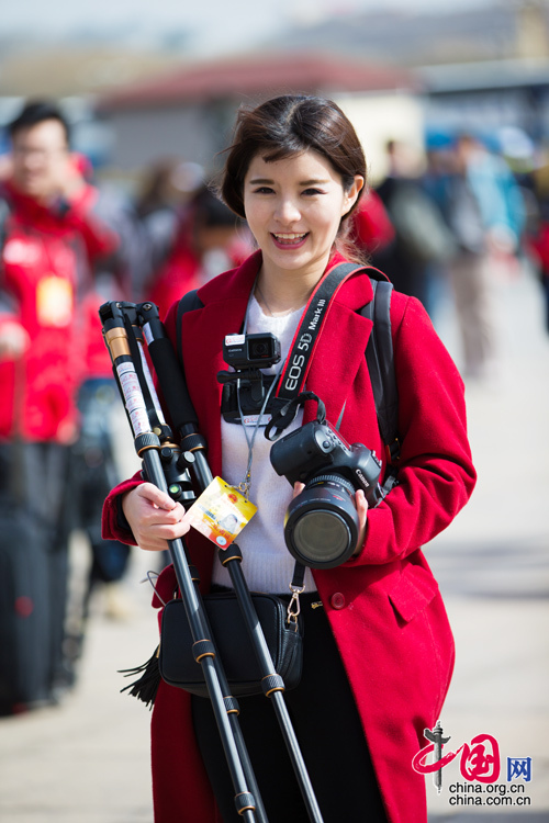 2016年兩會，人民大會大堂前，一位笑容燦爛的紅衣女記者正步入大會堂。中國網(wǎng) 鄭亮 攝